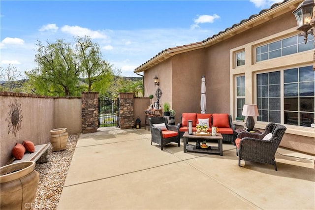 view of patio with a gate, fence, and an outdoor living space