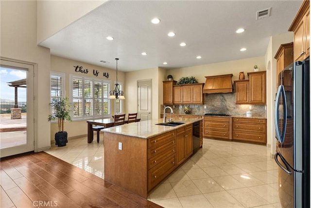 8072 Soft Winds Dr, Corona, CA 92883 - kitchen featuring black appliances, custom exhaust hood, brown cabinets, recessed lighting, and a center island with sink
