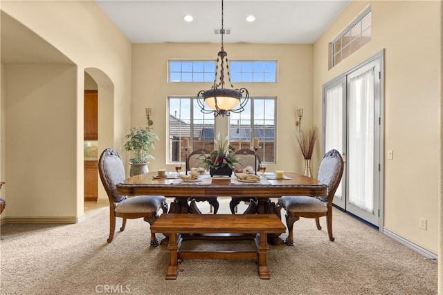 dining area with light carpet, baseboards, arched walkways, and recessed lighting