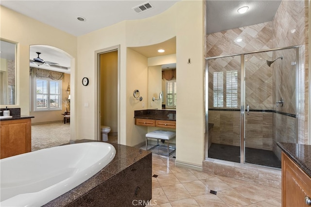 full bathroom featuring visible vents, toilet, a shower stall, vanity, and a bath