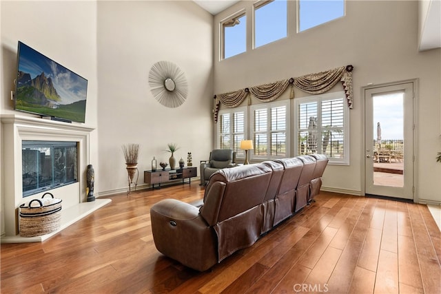 living room with a glass covered fireplace and wood finished floors