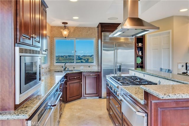 kitchen with island exhaust hood, a warming drawer, tasteful backsplash, a sink, and built in appliances