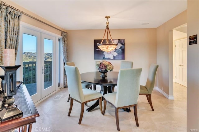 dining space featuring baseboards and french doors