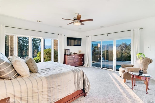 carpeted bedroom with access to outside, visible vents, and a ceiling fan