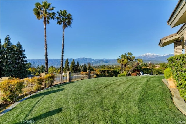 view of yard featuring a mountain view and fence