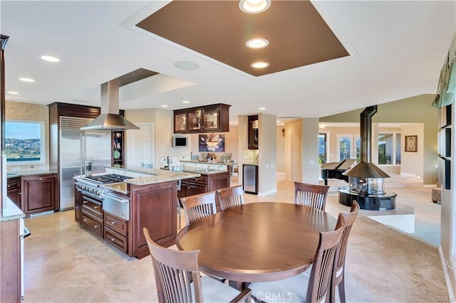 dining space featuring a wood stove, baseboards, and recessed lighting