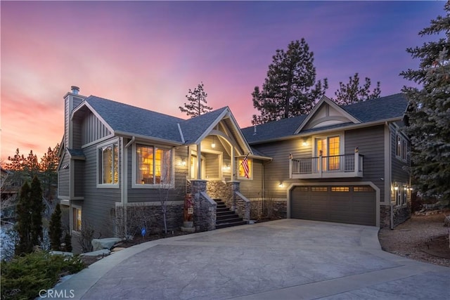 view of front of home with stairway, driveway, an attached garage, a chimney, and stone siding