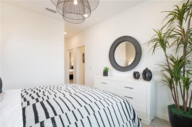 bedroom featuring light carpet, an inviting chandelier, and visible vents