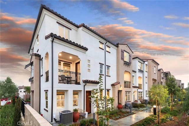 property at dusk featuring cooling unit