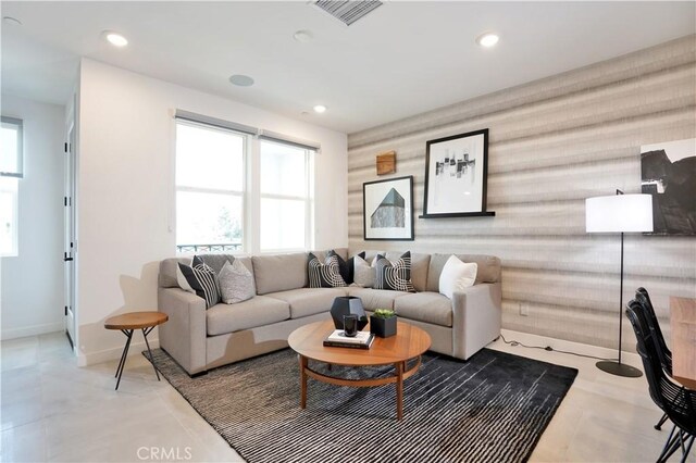 living area with recessed lighting, a healthy amount of sunlight, visible vents, and baseboards