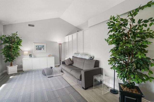 living room with lofted ceiling, baseboards, and visible vents