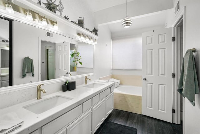 full bathroom featuring a garden tub, a sink, and visible vents