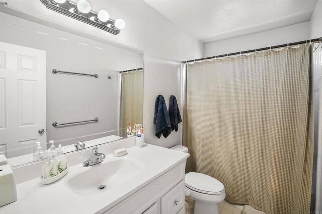 full bath featuring toilet, a shower with shower curtain, and vanity