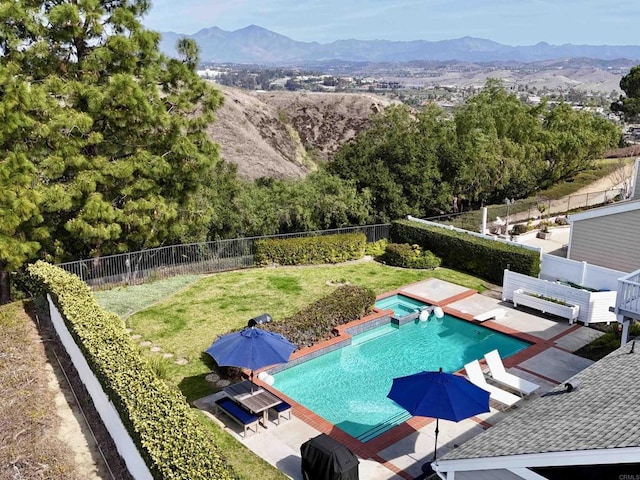 view of swimming pool with a pool with connected hot tub, a patio area, fence private yard, and a mountain view