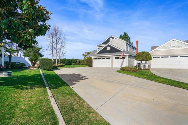 view of front facade with fence, a front lawn, and concrete driveway