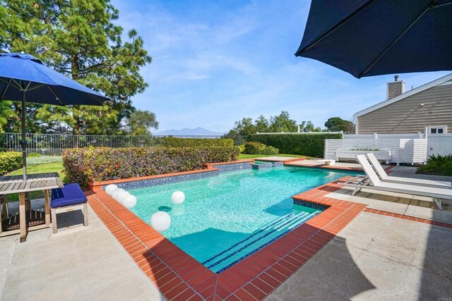 view of swimming pool with a fenced backyard, a mountain view, a fenced in pool, and a patio