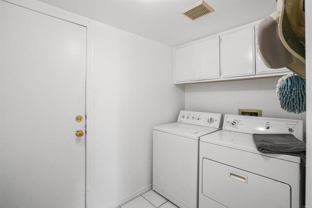 clothes washing area featuring cabinet space, light tile patterned floors, baseboards, visible vents, and independent washer and dryer