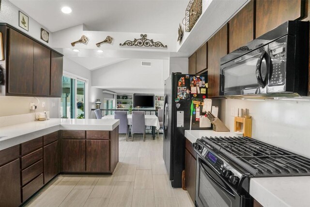 kitchen featuring lofted ceiling, a peninsula, open floor plan, light countertops, and black appliances