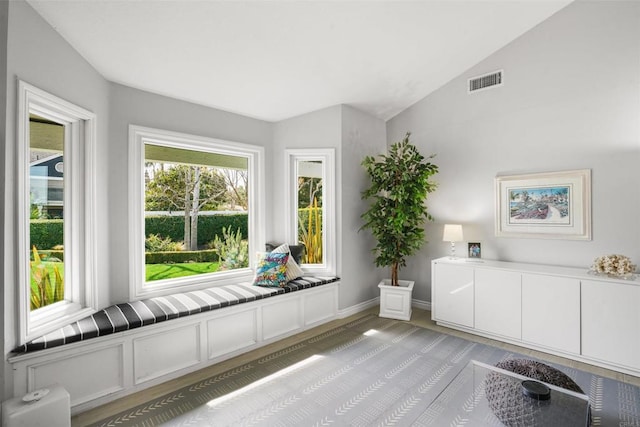 unfurnished room featuring visible vents, vaulted ceiling, and baseboards