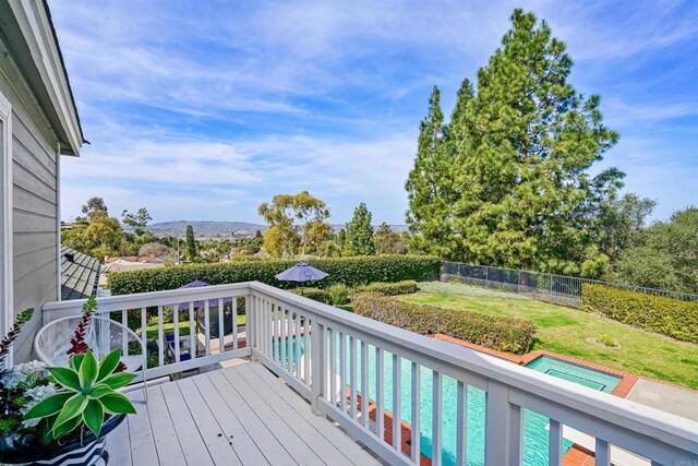 wooden deck featuring a fenced in pool, a fenced backyard, and a yard