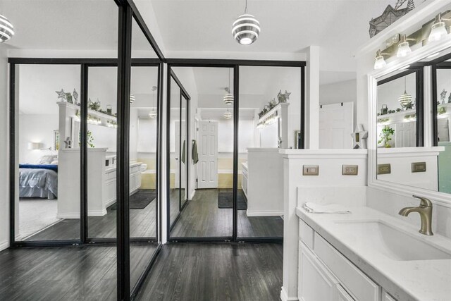 ensuite bathroom with wood finished floors, ensuite bath, and vanity