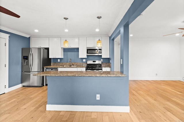 kitchen featuring a ceiling fan, a sink, white cabinets, appliances with stainless steel finishes, and crown molding