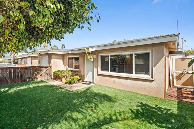 view of front of property featuring a gate, stucco siding, a front yard, and fence