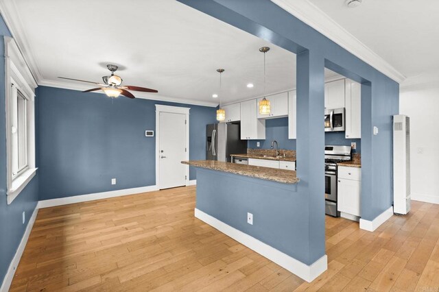 kitchen featuring a sink, ornamental molding, white cabinetry, and stainless steel appliances