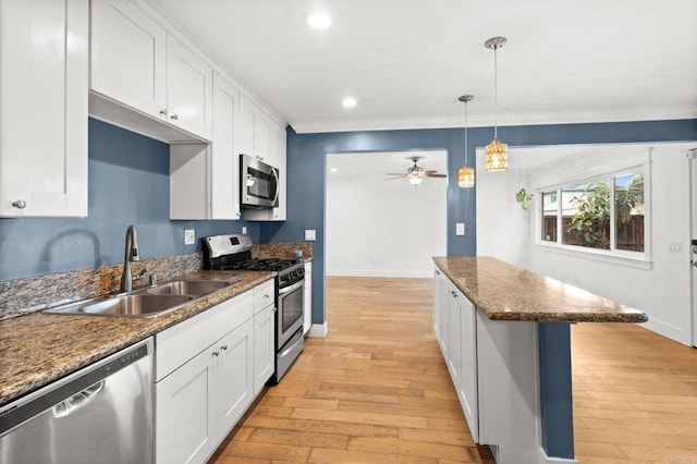 kitchen with a sink, appliances with stainless steel finishes, and white cabinetry