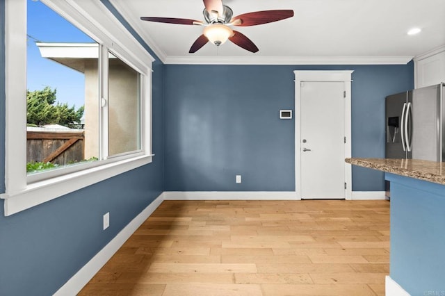 unfurnished room with baseboards, light wood-type flooring, ceiling fan, and ornamental molding