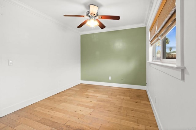 spare room featuring a ceiling fan, baseboards, light wood finished floors, and ornamental molding