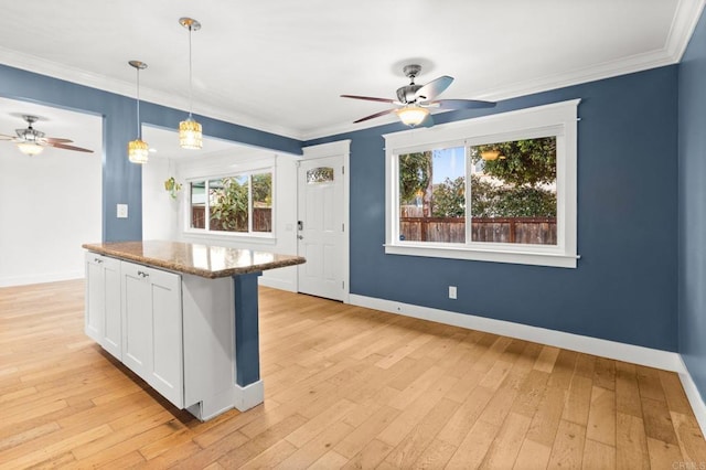 kitchen with a ceiling fan, light wood finished floors, and ornamental molding