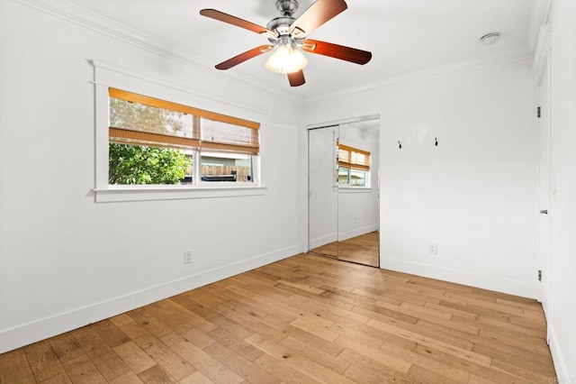 spare room with light wood finished floors, baseboards, ceiling fan, and ornamental molding