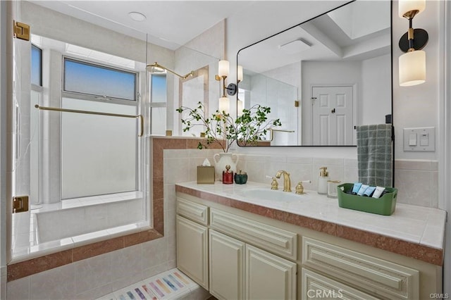 bathroom with tasteful backsplash, a tile shower, and vanity