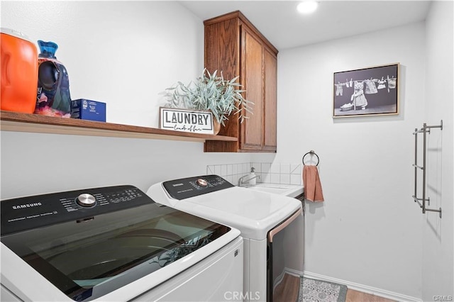 laundry room with cabinet space, recessed lighting, a sink, and washing machine and clothes dryer