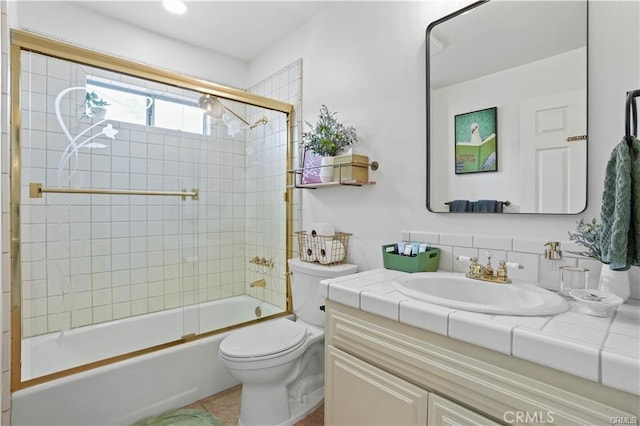 full bathroom with toilet, tile patterned floors, combined bath / shower with glass door, and vanity