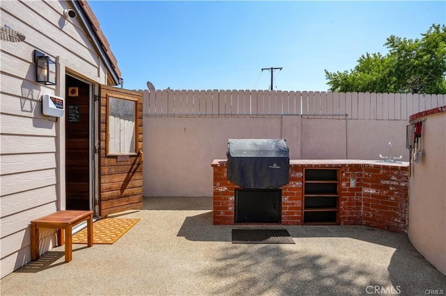 view of patio / terrace featuring a sink, fence, and a grill