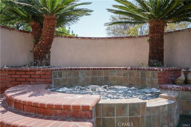 exterior details featuring fence and a hot tub