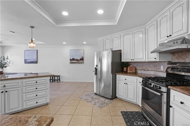 kitchen featuring light tile patterned floors, under cabinet range hood, appliances with stainless steel finishes, backsplash, and a tray ceiling