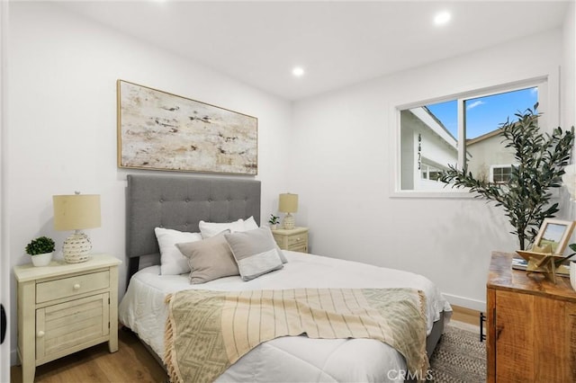 bedroom featuring baseboards, wood finished floors, and recessed lighting