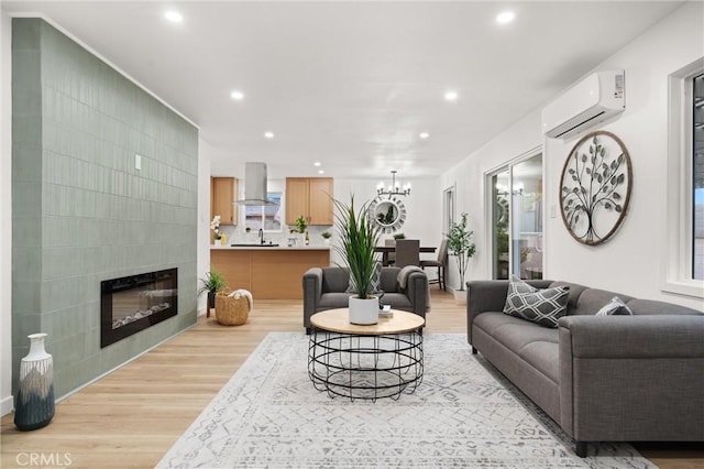 living area featuring a fireplace, a wall mounted air conditioner, wood finished floors, and recessed lighting