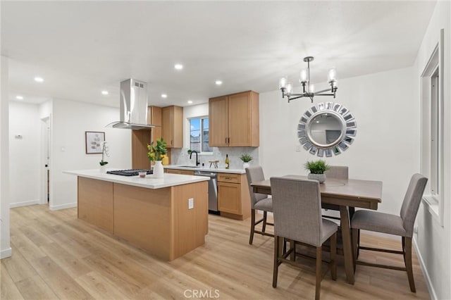 kitchen featuring tasteful backsplash, island range hood, light countertops, light wood-type flooring, and stainless steel dishwasher