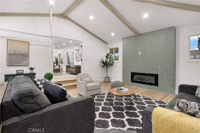 living area featuring a tile fireplace, vaulted ceiling with beams, recessed lighting, and wood finished floors