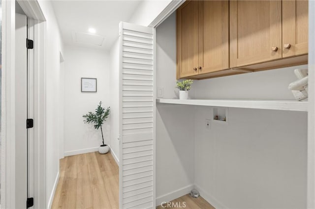 washroom with washer hookup, cabinet space, attic access, light wood-style floors, and baseboards