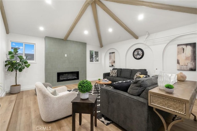 living room featuring a fireplace, light wood finished floors, recessed lighting, lofted ceiling with beams, and baseboards