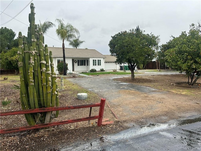 view of yard featuring fence and dirt driveway