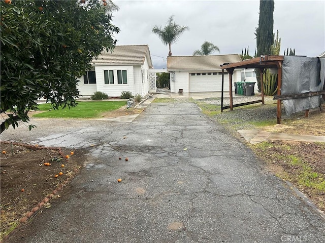 view of front of property with an attached garage, aphalt driveway, and a front yard