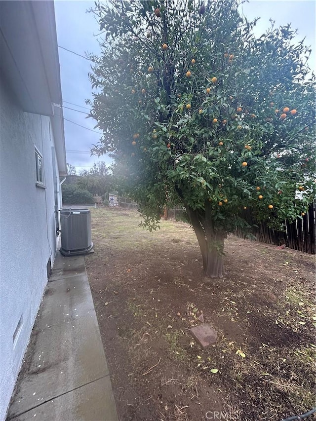 view of yard featuring fence and central AC