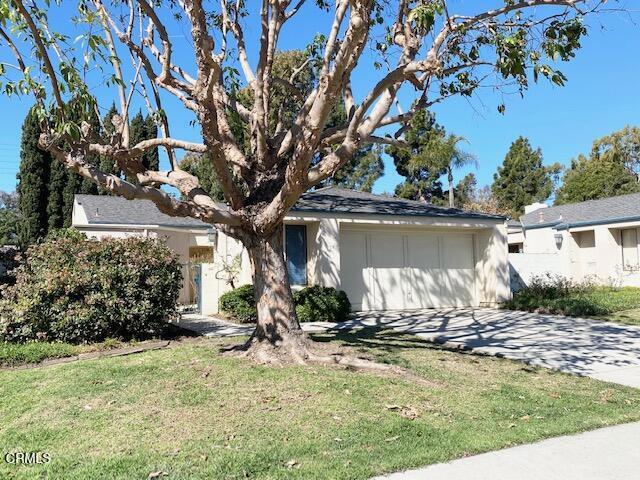 view of front of property featuring driveway, a front lawn, and an attached garage