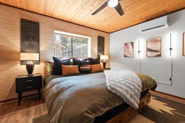 bedroom featuring a wall unit AC, wood ceiling, baseboards, and wood finished floors